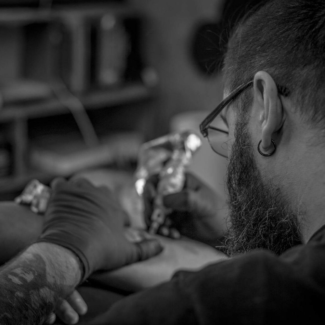 JOTA Tattoo Artist a tatuar com precisão no estúdio